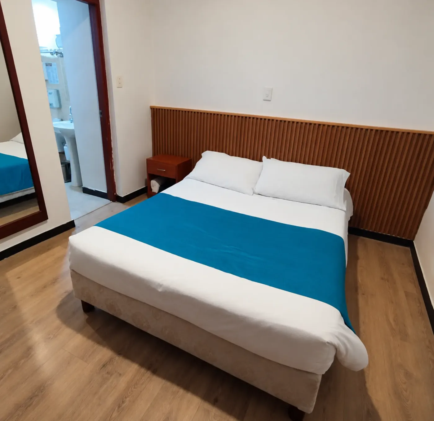 Habitación con cama doble, cabecero de madera y baño privado