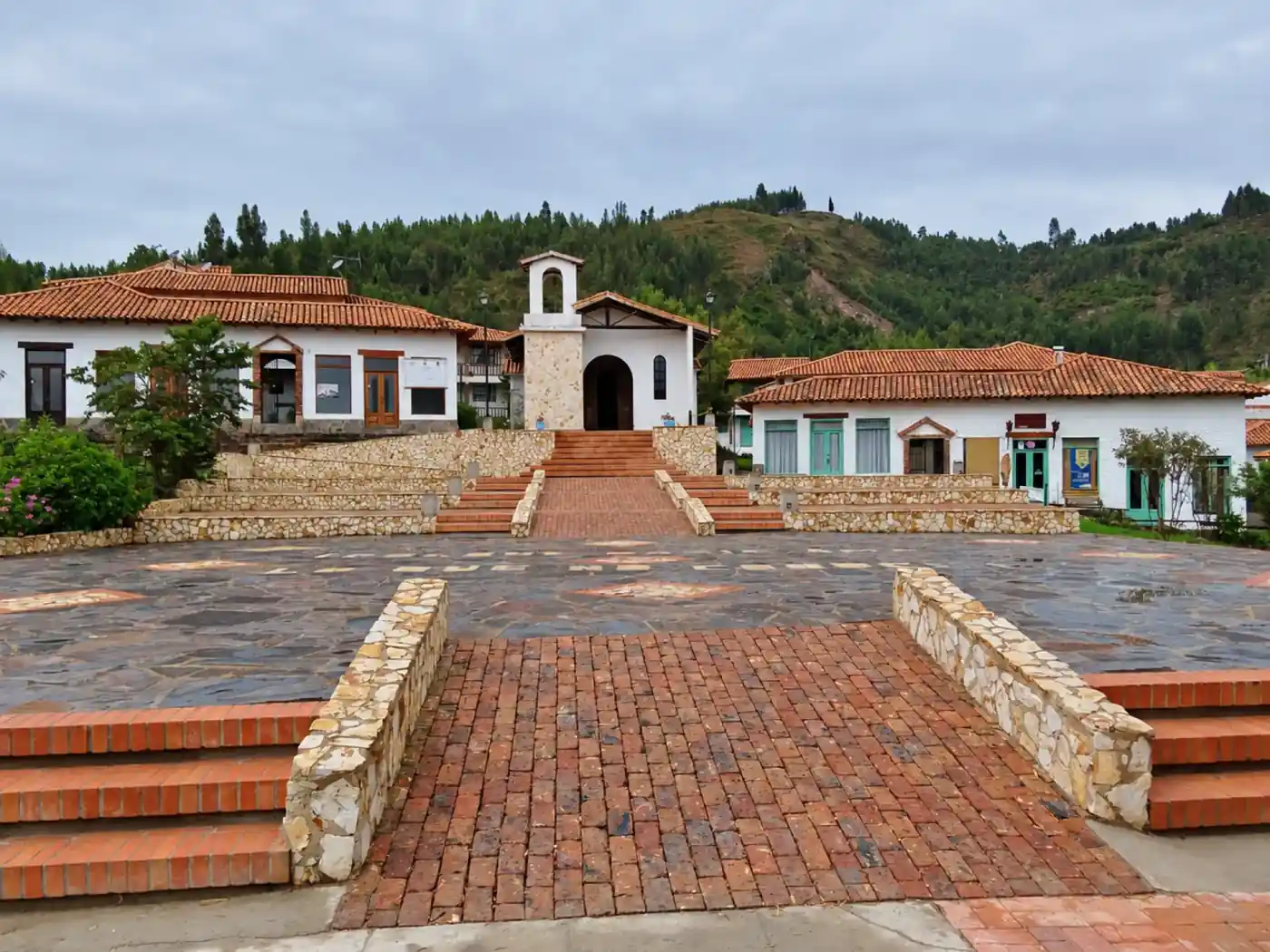 Plaza y capilla del Pueblito Boyacense con colinas verdes al fondo